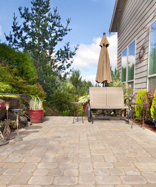 A patio with a table and chairs and an umbrella