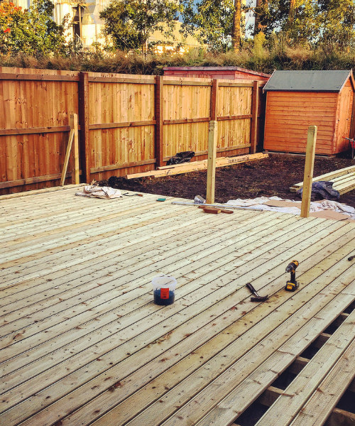 A wooden deck being built with a tool